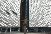 Ireland, North, Belfast, Titanic Quarter, Visitor centre designed by Civic Arts & Eric R Kuhne, with statue of diving woman in foreground.