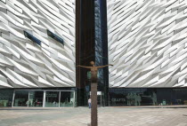 Ireland, North, Belfast, Titanic Quarter, Visitor centre designed by Civic Arts & Eric R Kuhne, with statue of diving woman in foreground.