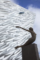 Ireland, North, Belfast, Titanic Quarter, Visitor centre designed by Civic Arts & Eric R Kuhne, with statue of diving woman in foreground.