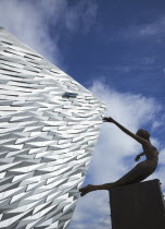 Ireland, North, Belfast, Titanic Quarter, Visitor centre designed by Civic Arts & Eric R Kuhne, with statue of diving woman in foreground.