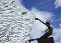 Ireland, North, Belfast, Titanic Quarter, Visitor centre designed by Civic Arts & Eric R Kuhne, with statue of diving woman in foreground.