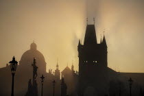 Czech Republic, Bohemia, Prague, The Calvary statue in early morning mist on Charles Bridge