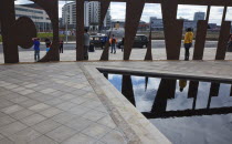 Ireland, North, Belfast, Titanic Quarter, Visitor centre designed by Civic Arts & Eric R Kuhne, tourist having pictures taken next to cut-out sign.