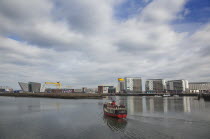 Ireland, North, Belfast, Titanic Quarter, Visitor centre designed by Civic Arts & Eric R Kuhne, tour boat taking tourists on sightseeing cruise.