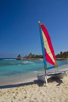 Mexico, Quintana Roo, Puerto Aventuras, View along beach with colourful hobie cat.