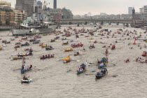 England, London, Flotilla of small rowing boats proceed along River Thames past HMS Belfast as part of the Queens Thames Diamond Jubilee Pageant, taken from Tower Bridge, 3rd June 2012.