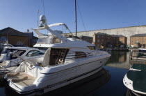 England, East Sussex, Brighton, apartment buildings in marina with moored motor boats and chalk cliffs behind.
