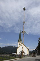 Austria, Tyrol, Brandenberg, Malbaum or Maypole outside village church.