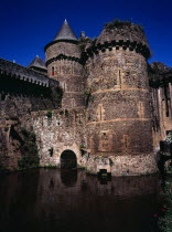 France, Bretagne, Ille-et-Vilaine, Fougeres. defensive walls and towers of the chateau dating from 11th to 15th century rising from moat.
