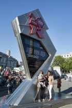 England,  London, Trafalgar Square, A family pose for a photograph in front of the Olympic Countdown clock.