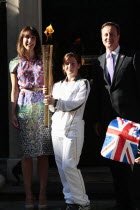 England, London, Olympic Torch relay in Downing Street, Samantha and Prime Minister David Cameron welcome the torch.