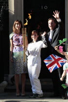 England, London, Olympic Torch relay in Downing Street, Samantha and Prime Minister David Cameron welcome the torch.