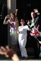England, London, Olympic Torch relay in Downing Street, Samantha and Prime Minister David Cameron welcome the torch.