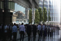 England, London, Southwark, Office workers reflected in glass building next to City Hall.