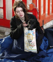 England, London, Big Issue seller with her dog.