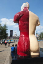 England, London, Two children pose for a photograph in front of the Hymn sculpture by artist Damian Hirst.