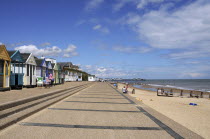 England, Suffolk, Southwold, Beach Huts near the pier Sea Defences and Holidaymakers.