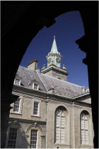 Ireland, County Dublin, Dublin City, Kilmainham, Royal Hospital clock tower viewed through an arch of the courtyard cloister.