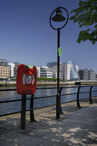 Ireland, County Dublin, Dublin City, river Liffey with the Convention Centre, streetlamp and lifebuoy in foreground.