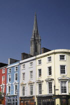 Ireland, County Cork, Cobh, St Colman's Cathedral overlooking colourful houses.