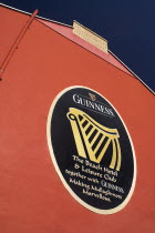 Ireland, County Sligo, Mullaghmore, advert for Guinness on red wall of the beach hotel.