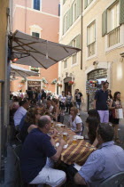 Italy, Lazio, Rome, Diners eating al fresco at a restaurant in back street.