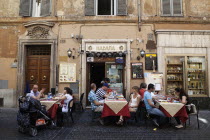 Italy, Lazio, Rome, Diners eating al fresco at a restaurant in a back street.