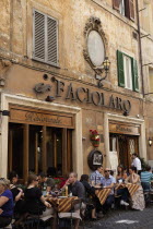 Italy, Lazio, Rome, Diners eating al fresco at a restaurant in a back street.