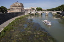 Italy, Lazio, Rome, Tourist boat on the Tiber River in front of the Bridge of Ponte Sant Angelo & Castel Sant Angelo .