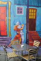 Mexico, Federal District, Mexico City, Condesa District, Argentinian restaurant with painted exterior depicting couple dancing the tango and table and chairs in foreground.