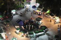 Mexico, Federal District, Mexico City, View onto Alameda park at night from Torre Latinoamericana with green and white striped roof awnings of street stalls below.
