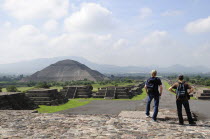 Mexico, Anahuac, Teotihuacan, Tourist couple taking in the view towards Pyramid del Sol.