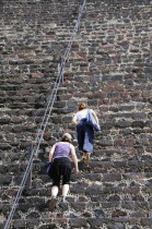 Mexico, Anahuac, Teotihuacan, Tourists climbing the steps of the Pyramid del Sol.