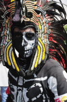 Mexico, Federal District, Mexico City, Portrait of Michacoa Aztec dancer in feather head-dress and painted face as Senor de Muerte or Mr Death performing in the Zocalo.
