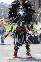 Mexico, Federal District, Mexico City, Michicoa Aztec dancer dressed in costume of Senor de Muerte or Mr Death for performance in the Zocalo.