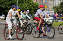 Mexico, Federal District, Mexico City, Cyclists on Reforma, one carrying small dog in basket on bicycle handlebars.