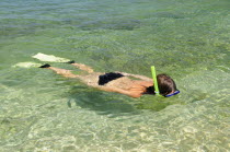 Mexico, Oaxaca, Huatulco, Woman snorkling in clear waters at Playa La Entrega.