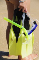 Mexico, Oaxaca, Huatulco, Playa La Entrega, Cropped shot of woman snorkler carrying mask and flippers.