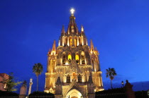 Mexico, Bajio, San Miguel de Allende, La Parroquia de San Miguel Arcangel neo-gothic exterior illuminated at night.