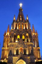 Mexico, Bajio, San Miguel de Allende, La Parroquia church, neo-gothic exterior illuminated at night.