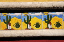 Mexico, Bajio, San Miguel de Allende, Detail of colourful tile depicting figure in Mexican hat sitting at foot of cactus.