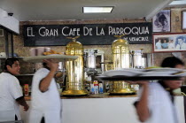 Mexico, Veracruz, Cafe El Gran Cafe de la Parroquia interior with waiters carrying laden trays past bar area.