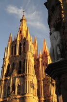 Mexico, Bajio, San Miguel de Allende, La Parroquia de San Miguel Arcangel neo-gothic exterior with statue of Ignacio Allende in foreground.