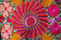 Mexico, Bajio, San Miguel de Allende, Detail of brightly embroidered textile in arts shop with flower design in pink, red and orange.