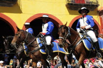 Mexico, Bajio, San Miguel de Allende, Independence Day celebrations. Re-enactment of the Call for Independence, horsemen ride through street with watching crowd.