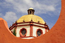 Mexico, Bajio, San Miguel de Allende, Dome of the Parroquia church part framed by orange painted wall.
