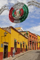 Mexico, Bajio, San Miguel de Allende, Independence Day decorations adorn colonial street lined by colourful buildings.