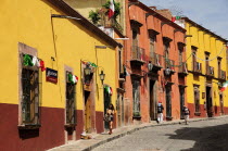 Mexico, Bajio, San Miguel de Allende, Independence Day decorations adorn colonial streets lined by brightly painted buildings.