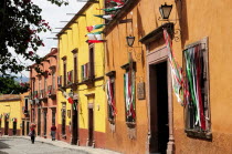 Mexico, Bajio, San Miguel de Allende, Independence Day decorations adorn colonial street lined with brightly painted buildings.