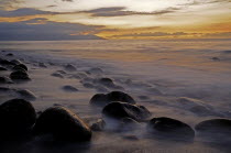 Mexico, Jalisco, Puerto Vallarta, Waves and rocks on beach at sunset.